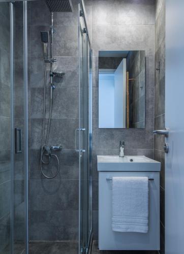 a bathroom with a shower and a sink and a mirror at Spot Apart in Athens