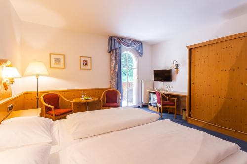 a hotel room with two beds and a desk at Hotel Erbprinzenpalais in Wernigerode