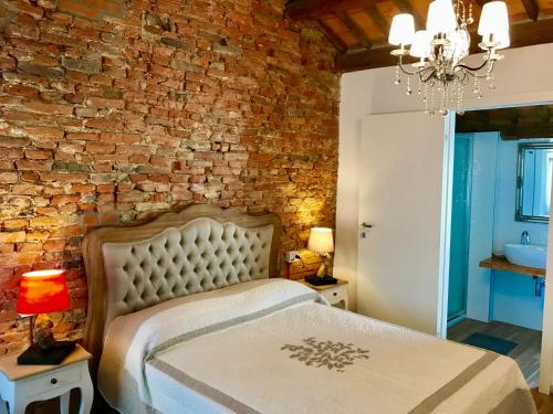 a bed in a room with a brick wall at Barbara’s rooms in Chioggia