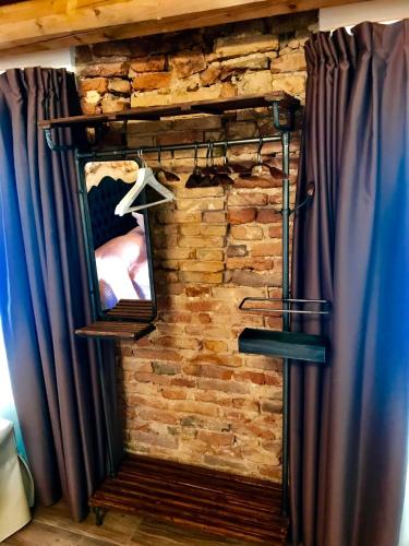 a mirror in a room with a stone wall at Barbara’s rooms in Chioggia