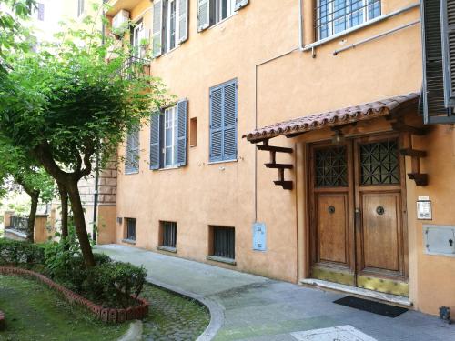 a building with a wooden door next to a tree at Alex Place in Rome