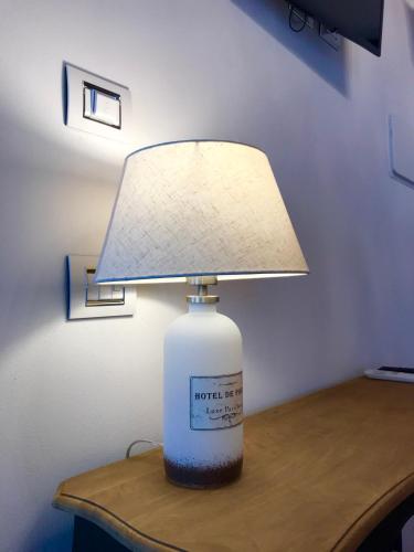 a lamp on a table with a large bottle on it at Barbara’s rooms in Chioggia