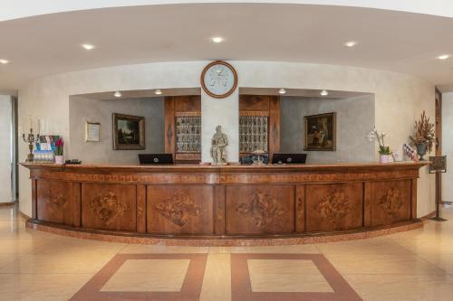 a large lobby with a clock on the wall at Hotel Michelangelo in Sassuolo