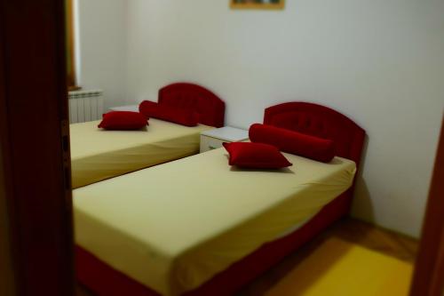 two beds in a room with red pillows on them at Villa AMANI in Sarajevo