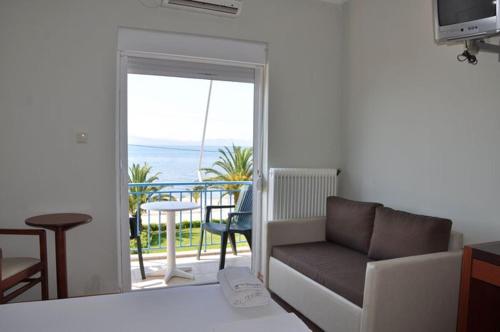 a living room with a couch and a balcony at Elena Hotel in Arkítsa
