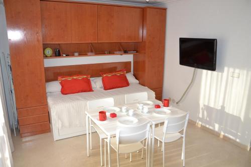 トレビエハにあるApartamento Rodのテーブルと赤い枕付きのベッドが備わる客室です。