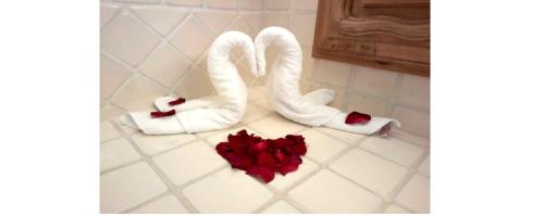 a bathroom with white towels and red rose pedals at Il Piccolo Peccato in Cuernavaca