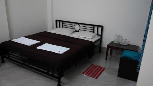 a bedroom with a bed with a mirror and a table at Cozy Living in Guwahati