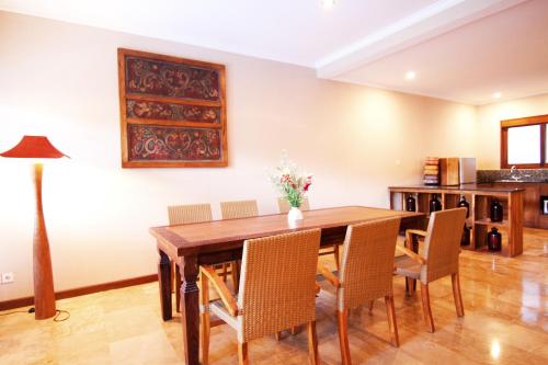 a dining room with a wooden table and chairs at Ajanta Villa in Sanur