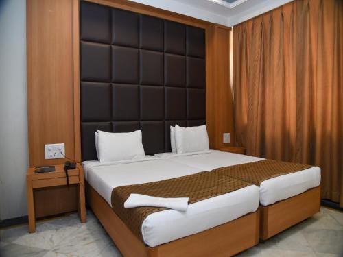 Un dormitorio con una cama grande con un cabecero grande. en Hotel Windsor, en Patna