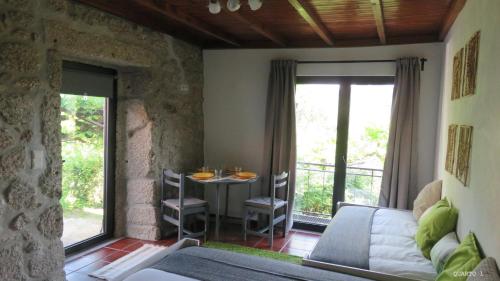 a room with a bed and a table with chairs at Casa do Contador T3 / T6 in Vieira do Minho