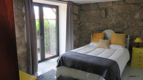 sypialnia z dużym łóżkiem i oknem w obiekcie Casa do Contador T3 / T6 w mieście Vieira do Minho