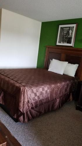 a bedroom with a bed and a desk at Island Inn in Grand Island