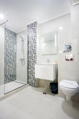 a bathroom with a toilet and a sink and a shower at Lotus 7 Silver in Mamaia