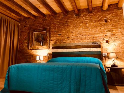 a bedroom with two blue beds in a brick wall at Barbara’s rooms in Chioggia
