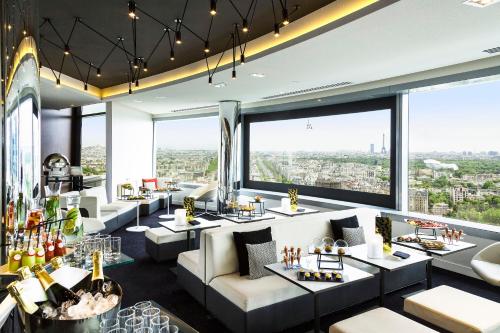 
a dining room with a large window overlooking a city at Melia Paris La Defense in Courbevoie
