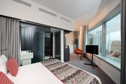 a bedroom with a large bed and a large window at Melia Paris La Defense in Courbevoie