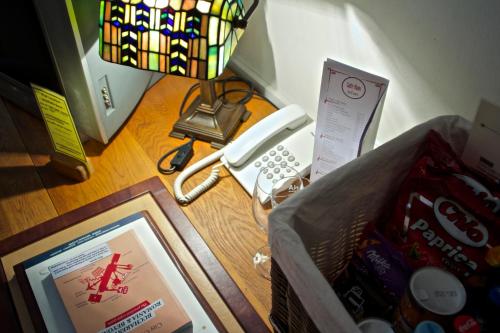 a room with a desk with a phone and a picture at Rembrandt Old Town in Bucharest