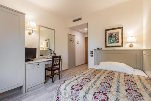 a bedroom with a bed and a desk with a computer at Hotel Michelangelo in Sassuolo