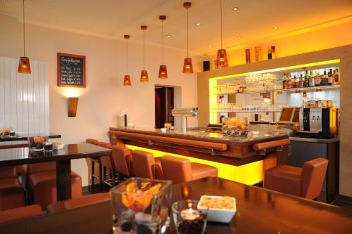 a restaurant with tables and chairs and a bar at Air Hotel Wartburg in Düsseldorf