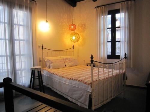 um quarto com uma cama num quarto com janelas em House of memories em Neápolis