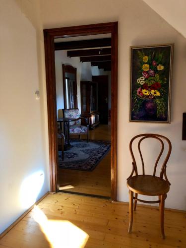 a hallway with a chair and a painting on the wall at The Houses of History - anno 1830 in Tihany