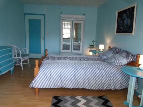 ein Schlafzimmer mit einem großen Bett und zwei Tischen in der Unterkunft Domisiladore in Le Molay-Littry