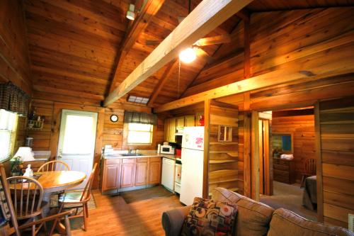 a kitchen and dining room of a log cabin at Country Road Cabins in Hico