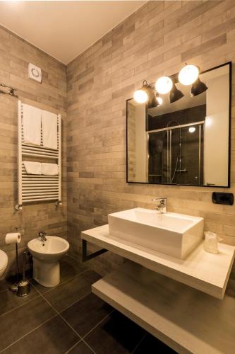 a bathroom with a sink and a toilet and a mirror at Hotel Napoleon Susa in Susa