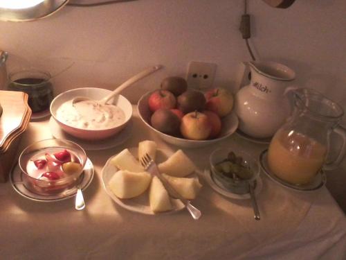 a table with a bowl of apples and a bowl of fruit at Gästehaus ERLE in Ramsau am Dachstein