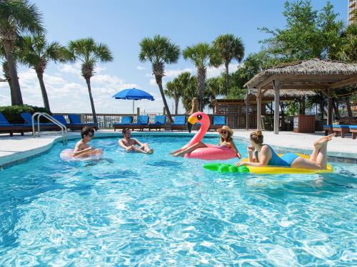a group of children playing in a swimming pool at Surf & Sand Hotel in Pensacola Beach