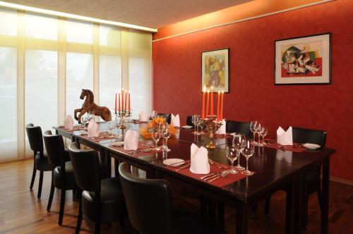 a long table in a room with red walls at Air Hotel Wartburg in Düsseldorf
