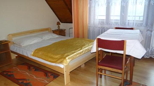 シュツァブニツァにあるPokoje Kasprzakのベッドルーム1室(ベッド1台、テーブル、椅子付)