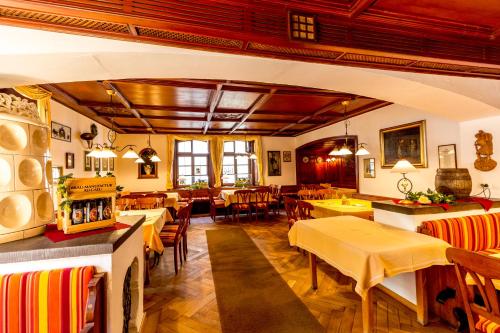 a restaurant with tables and chairs in a room at Hotel Gasthof Post in Nesselwang