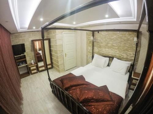 a bedroom with a canopy bed and a couch at Melrose House Hotel in Pamukkale