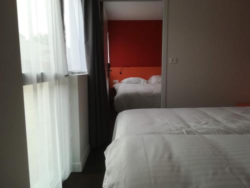 a hotel room with two beds and a window at Atao Residence- Rennes Sud in Vern-sur-Seiche