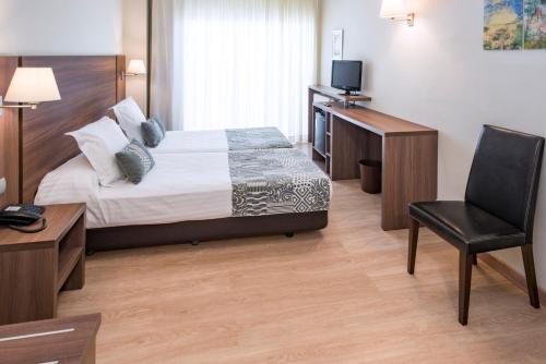 1 dormitorio con cama, escritorio y silla en Golden Acqua Salou en Salou