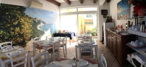 Giglio Del Conero في نومانا: مطعم به طاولات وكراسي ومطل على المحيط