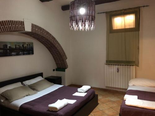 a bedroom with two beds and a chandelier at Casa Traiano in Benevento