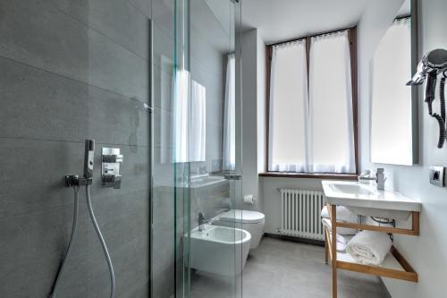 a bathroom with a shower and a toilet and a sink at Le Funi Hotel in Bergamo