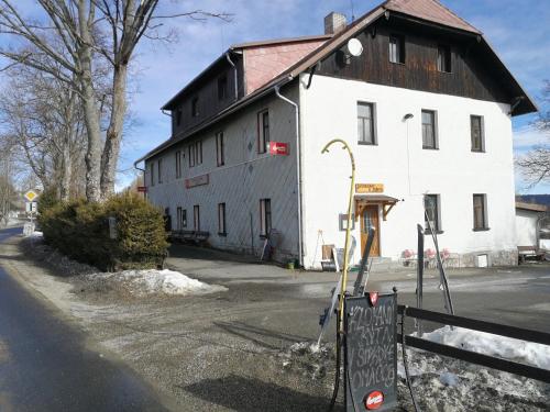 a large white building with a wooden roof at Penzion Vozzýk in Nové Hutě