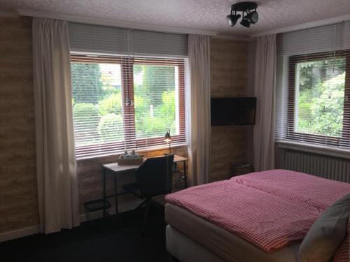 a bedroom with a bed and a desk and a window at Landhaus Thome in Nideggen