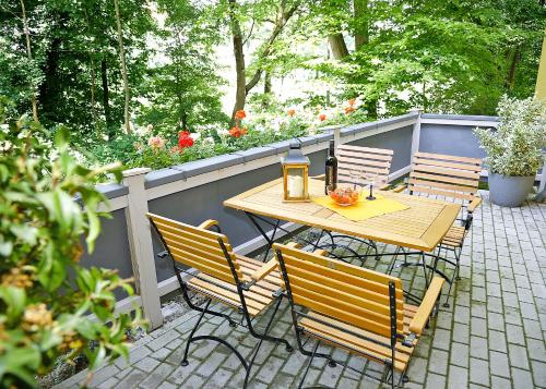 einen Holztisch und Stühle auf einer Terrasse in der Unterkunft Haus Eveline - Ferienwohnungen unterhalb der Wartburg - in Eisenach