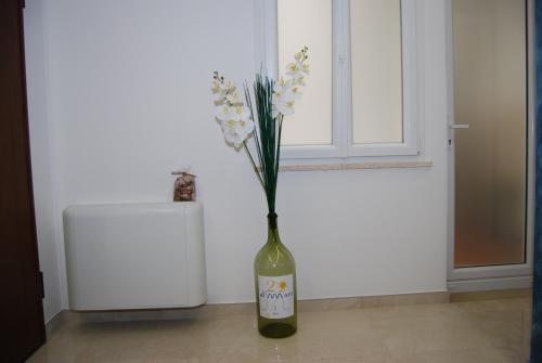un vase avec des fleurs assis sur le sol dans l'établissement Ventidimaregallipoli, à Gallipoli