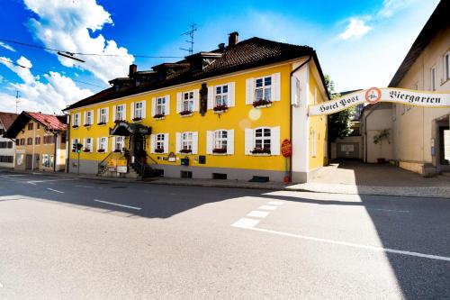 a yellow building on the side of a street at Hotel Gasthof Post in Nesselwang