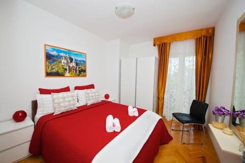 a bedroom with a red and white bed and a chair at Melanija 1 in Rovinj