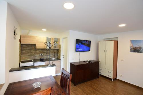 a kitchen with white walls and a wooden floor at Apartment Bea with FREE BIKE and BIKE STORAGE in Koper
