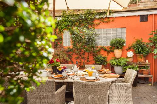 una mesa al aire libre con comida y sillas en Guesthouse Maison de la Rose, en Brujas
