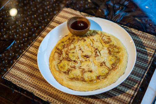 een pizza op een wit bord op een tafel bij Radiance Sunset Villas Lembongan in Nusa Lembongan