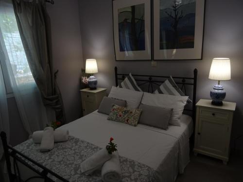 a bedroom with a bed with white sheets and pillows at Vasia's Artistsvillas in Gaios
